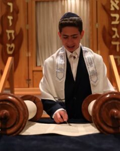 A boy during his bar mitzvah reading Torah portion at the sanctuary as part of lifecycle events in Temple Israel in NJ.